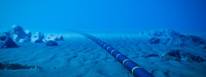 Underwater fiber-optic cable on ocean floor.